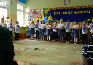 Dzieci śpiewają piosenkę jednoczeście pokazując jej słowa